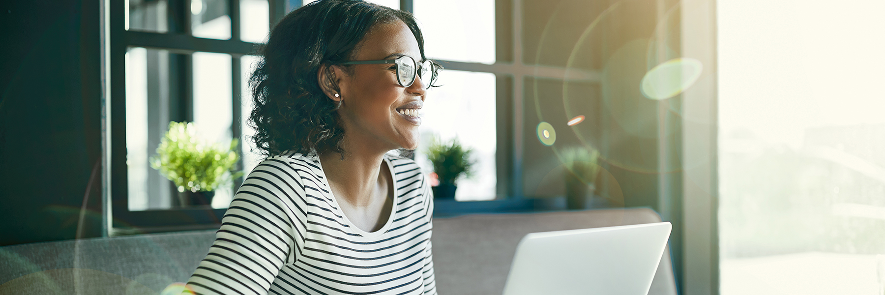 Woman working at a laptop in front of a window