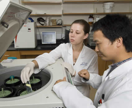 Two biomedical engineering 色花堂_色花堂 98堂 students working with a centrifuge in a research lab