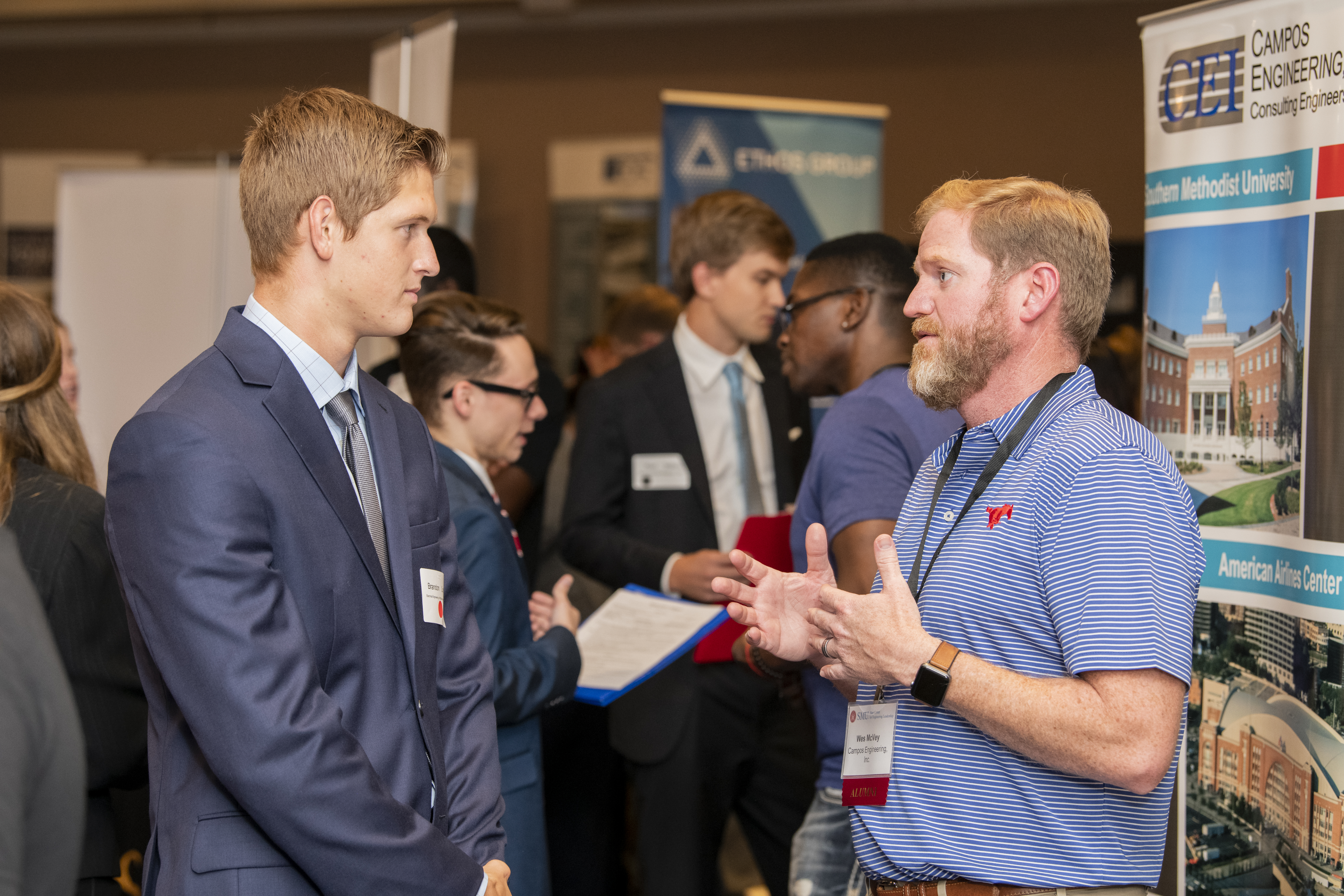 Students engaged in conversation at an engineering leadership event at 色花堂_色花堂 98堂 Lyle School of Engineering. Individuals in business and casual attire are networking in a professional setting.