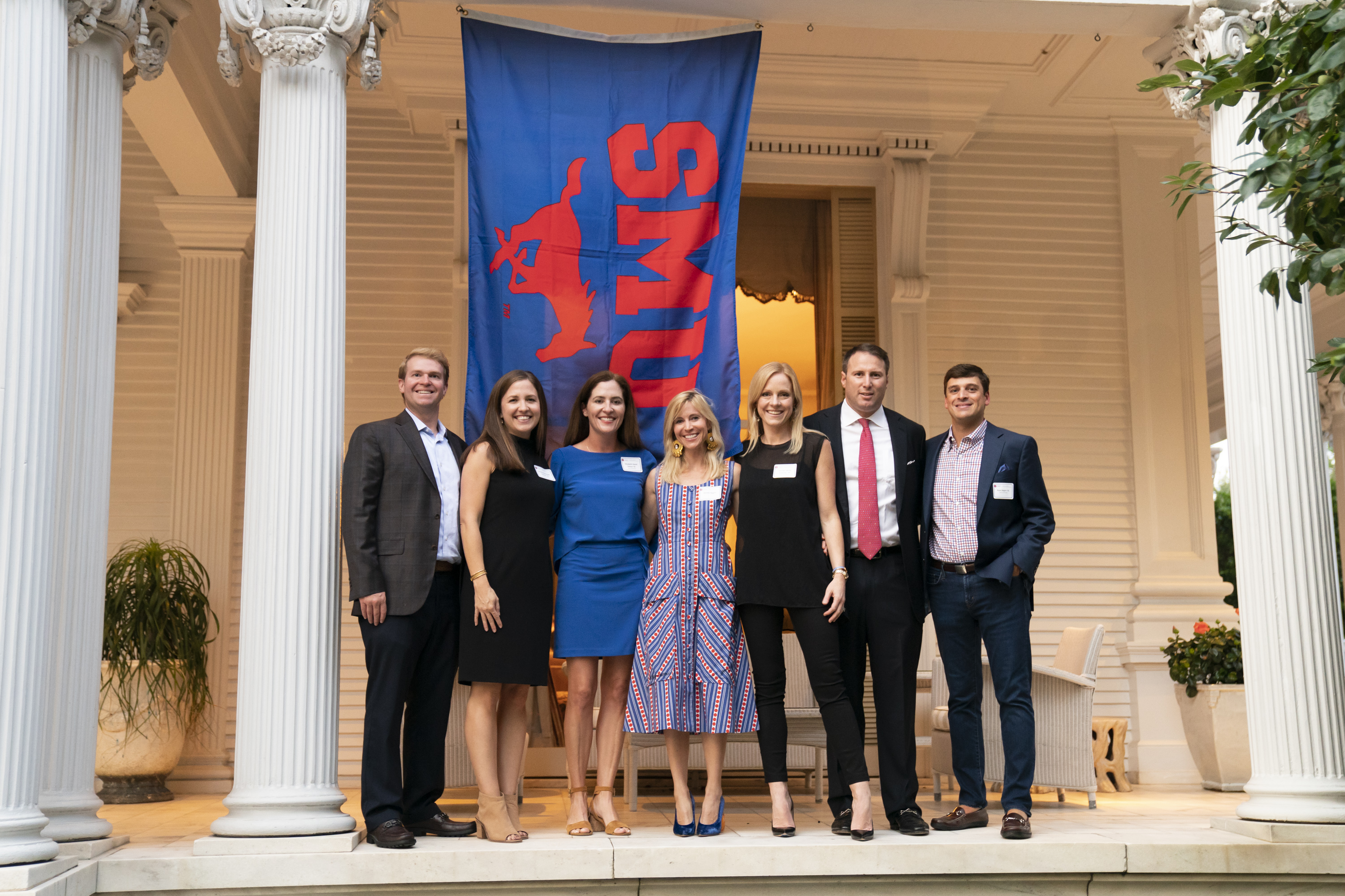 Guests stand outside of the Wedding Cake House in front of an 色花堂_色花堂 98堂 flag.