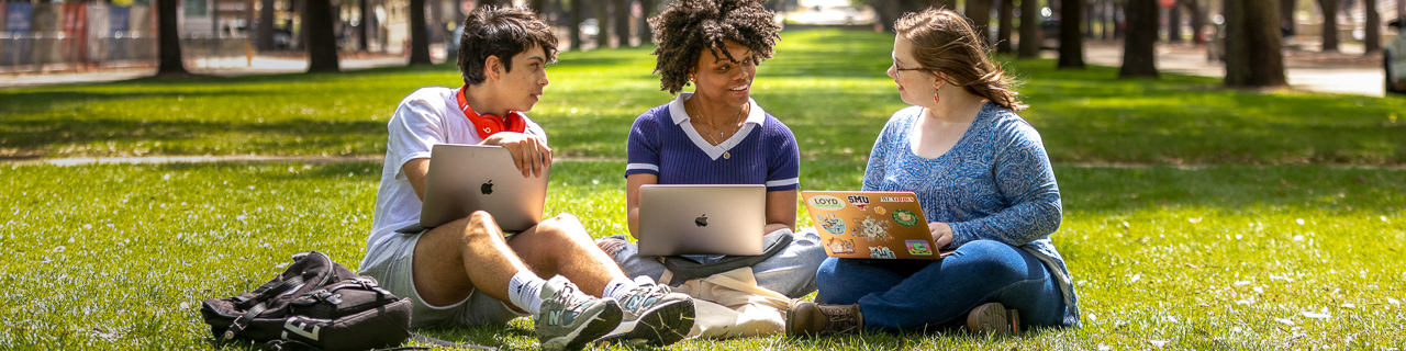 Students collaborate on a project on the lawn outside of Dallas Hall
