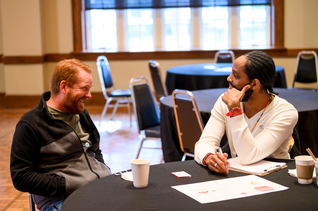 two men talking at a table