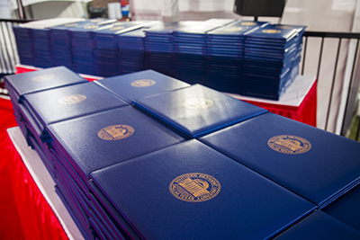 A table featuring several diplomas stacked and spread out