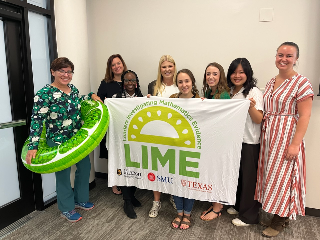 LIME project faculty and participants hold a flag with the LIME logo.